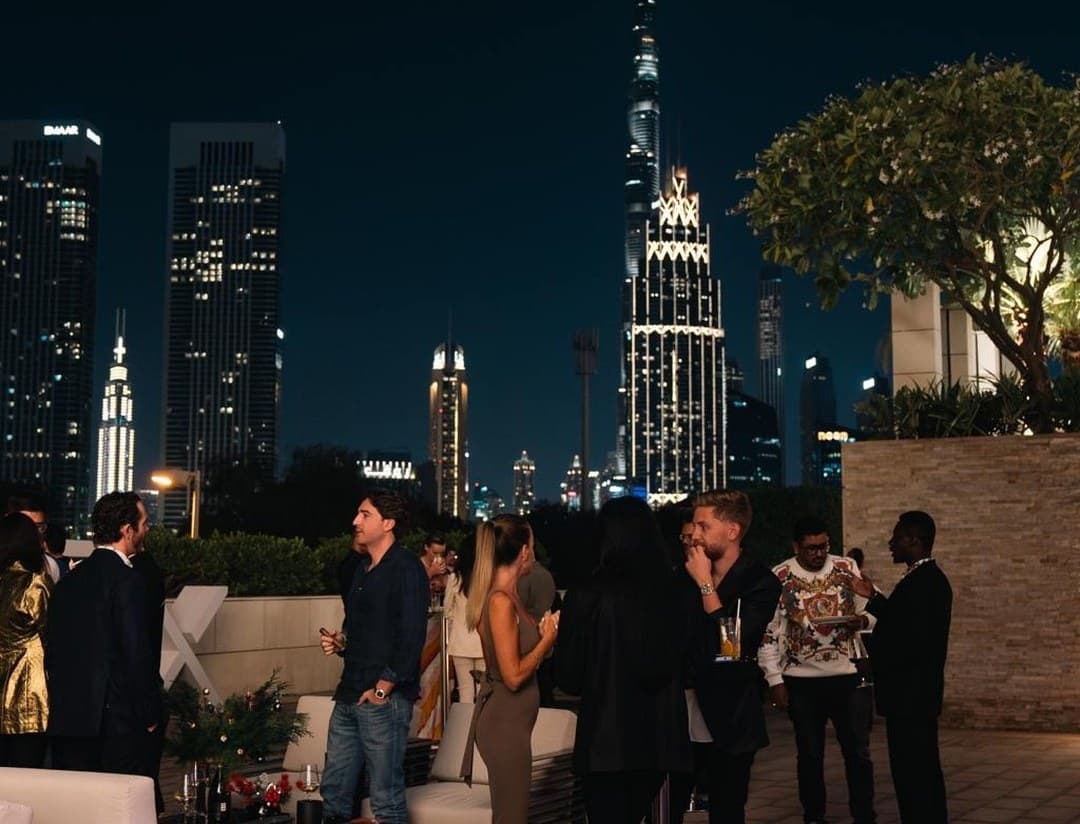 Guests networking on the 37x terrace, Burj Khalifa behind
